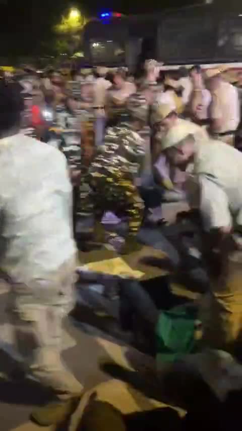 Police pull sitting protesters off the road at night